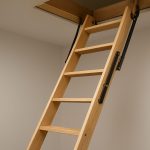 A durable wooden loft ladder extending from a ceiling hatch in a modern living space.